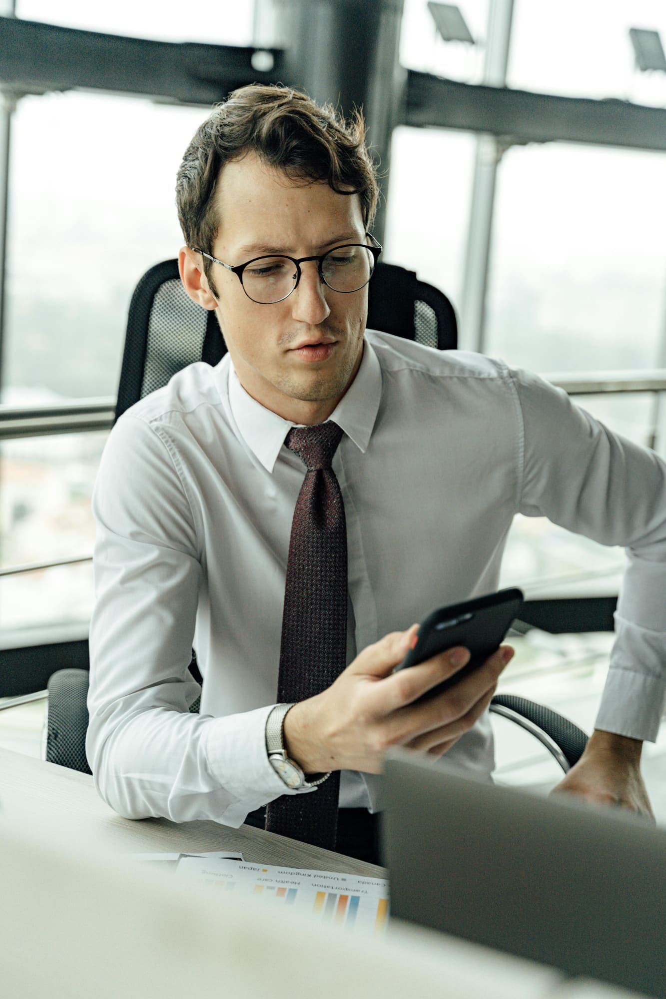 A person checks an incoming notification on their phone at a desk